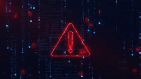 Digital cybersecurity warning symbol with red glowing exclamation mark overlayed on binary code background representing deepfake cyber attacks in 2025